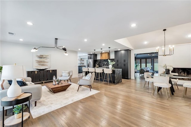 living room with light hardwood / wood-style flooring and an inviting chandelier