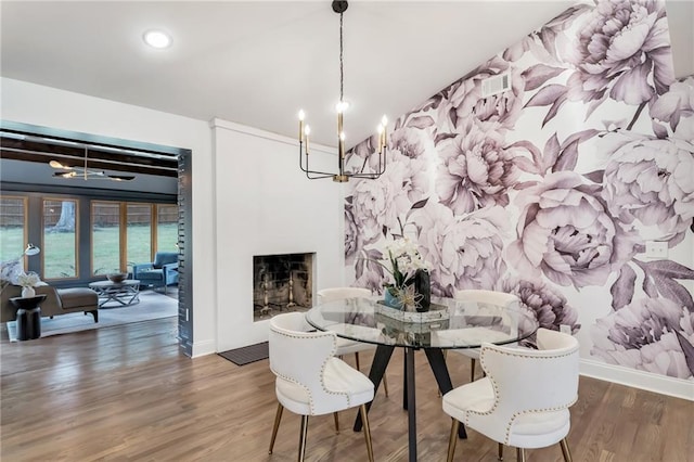 dining space featuring dark hardwood / wood-style flooring and an inviting chandelier