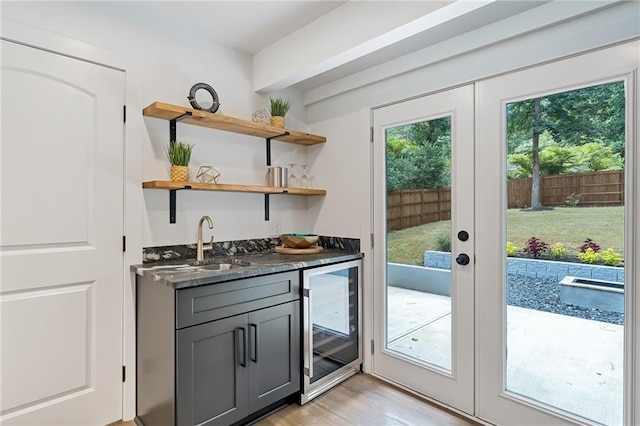 doorway featuring french doors, light hardwood / wood-style flooring, wine cooler, and indoor wet bar