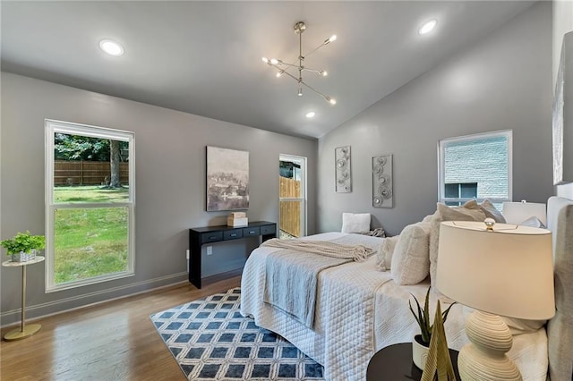 bedroom featuring light hardwood / wood-style flooring, multiple windows, and a notable chandelier