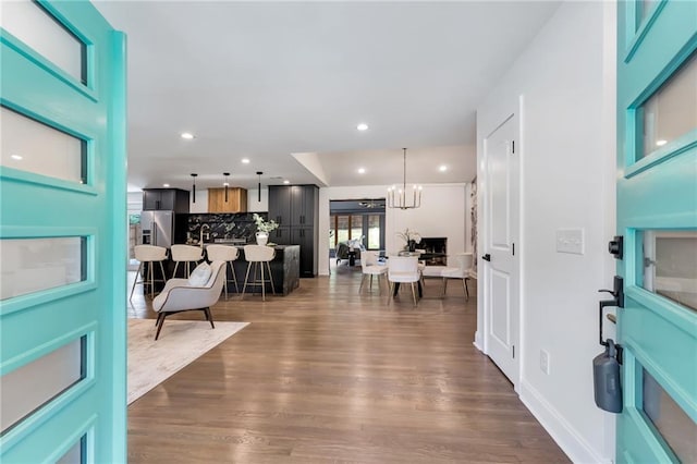 foyer entrance with a notable chandelier and dark wood-type flooring