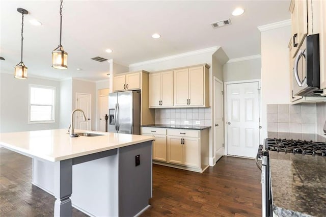 kitchen with a center island with sink, sink, decorative backsplash, decorative light fixtures, and stainless steel appliances