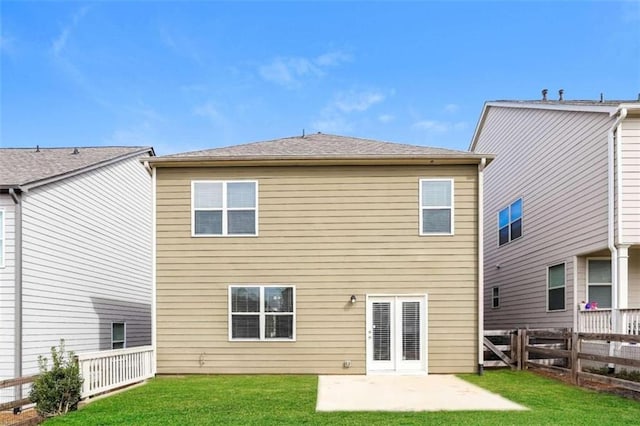 back of property with a yard and a patio area