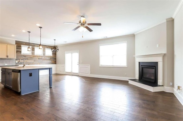 kitchen featuring ceiling fan, dishwasher, hanging light fixtures, crown molding, and a kitchen island with sink