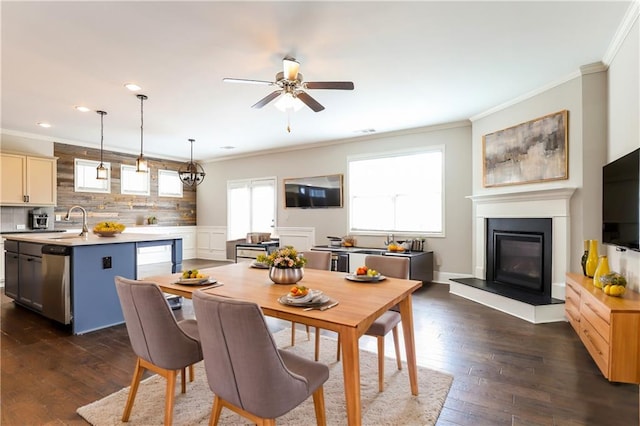 dining space featuring ceiling fan, dark hardwood / wood-style floors, ornamental molding, and sink