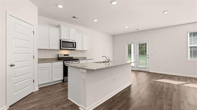 kitchen featuring appliances with stainless steel finishes, dark hardwood / wood-style floors, white cabinetry, sink, and a center island with sink