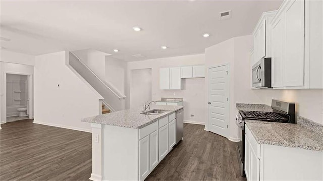 kitchen with appliances with stainless steel finishes, sink, a kitchen island with sink, and white cabinets