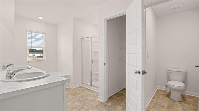 bathroom featuring vanity, toilet, and an enclosed shower