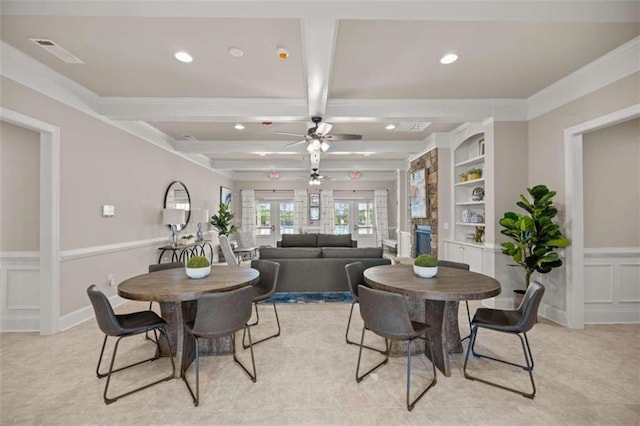 dining room with beamed ceiling, ornamental molding, light colored carpet, built in shelves, and french doors