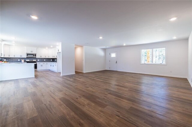 96 Sam Alexander Rd, Douglasville, GA 30134 - unfurnished living room featuring dark wood-type flooring, baseboards, and recessed lighting