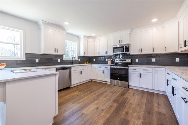 96 Sam Alexander Rd, Douglasville, GA 30134 - kitchen featuring dark wood-style floors, white cabinets, decorative backsplash, and appliances with stainless steel finishes