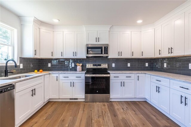 96 Sam Alexander Rd, Douglasville, GA 30134 - kitchen featuring white cabinetry, light wood-style flooring, a sink, and appliances with stainless steel finishes
