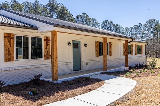 96 Sam Alexander Rd, Douglasville, GA 30134 - view of front of house featuring brick siding, a porch, a standing seam roof, and metal roof