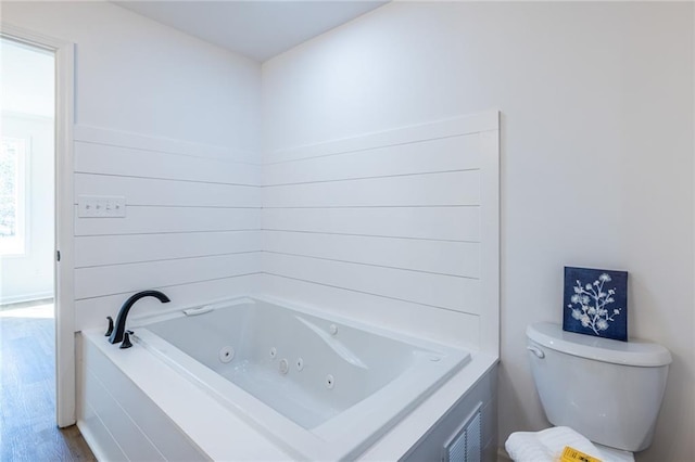 96 Sam Alexander Rd, Douglasville, GA 30134 - full bathroom with visible vents, a tub with jets, toilet, and wood finished floors