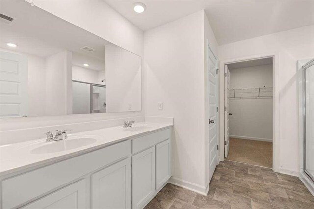 bathroom with vanity and a shower with door