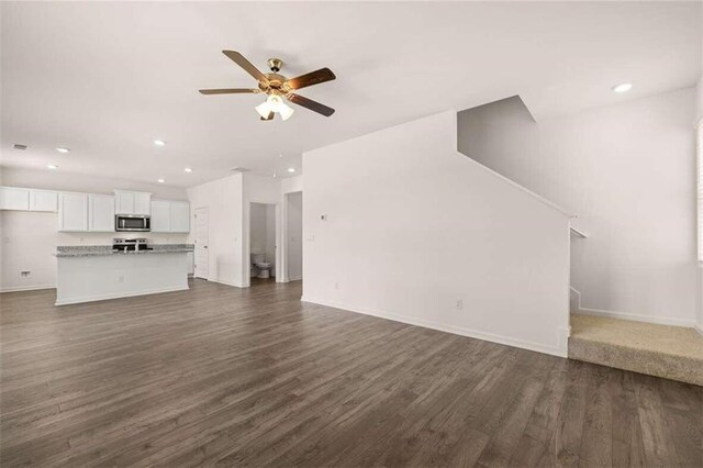 unfurnished living room with ceiling fan and dark hardwood / wood-style flooring