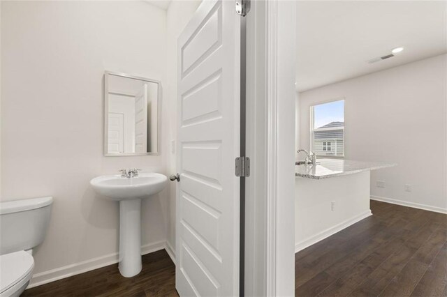 bathroom with sink, hardwood / wood-style floors, and toilet