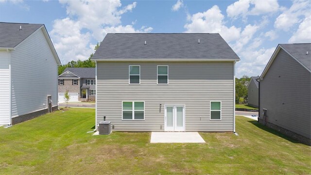 rear view of property with a lawn, central AC unit, and a patio