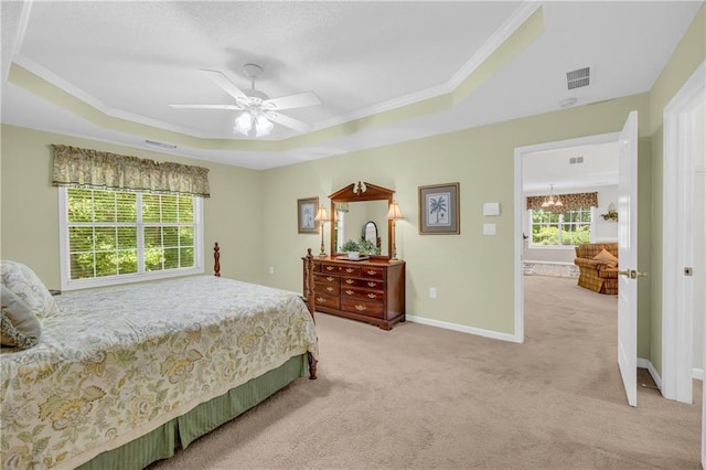 bedroom featuring a tray ceiling, light colored carpet, crown molding, a ceiling fan, and baseboards