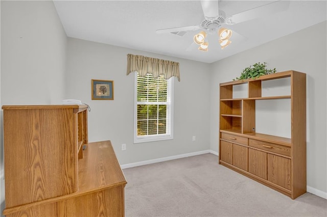unfurnished office with a ceiling fan, light carpet, and baseboards