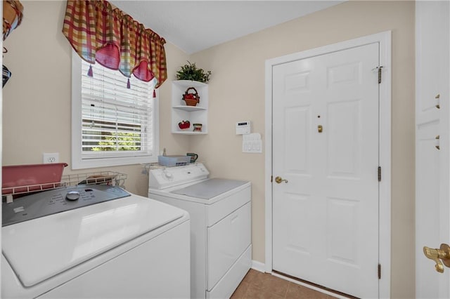 laundry area with independent washer and dryer and light tile patterned floors