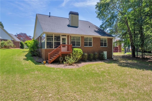 rear view of property with brick siding, a lawn, a chimney, and a shingled roof