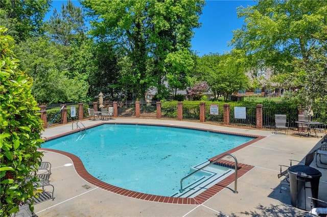 community pool featuring fence and a patio