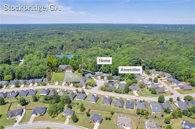 view of property location with a heavily wooded area and nearby suburban area