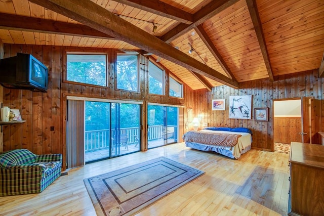 bedroom with access to exterior, wooden walls, light wood finished floors, and beam ceiling