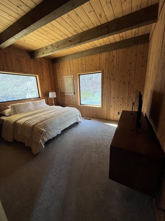 bedroom with wooden ceiling, carpet, wooden walls, and beamed ceiling