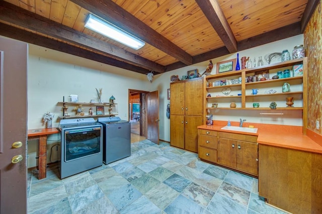 interior space featuring brown cabinetry, a sink, washer and dryer, wooden ceiling, and beamed ceiling