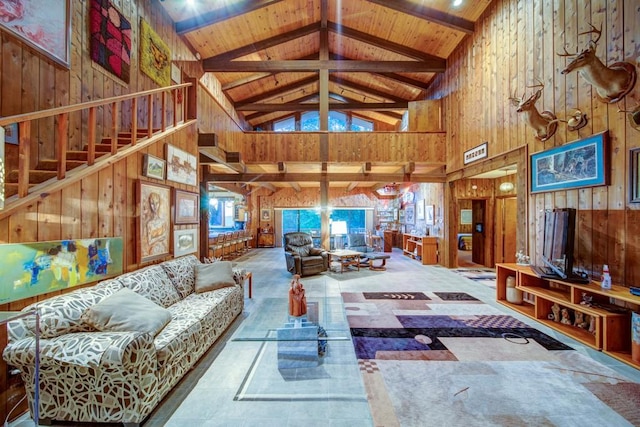 living room with stairs, high vaulted ceiling, wood walls, and wood ceiling