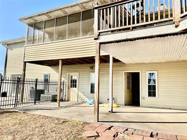 rear view of house with a sunroom and a patio