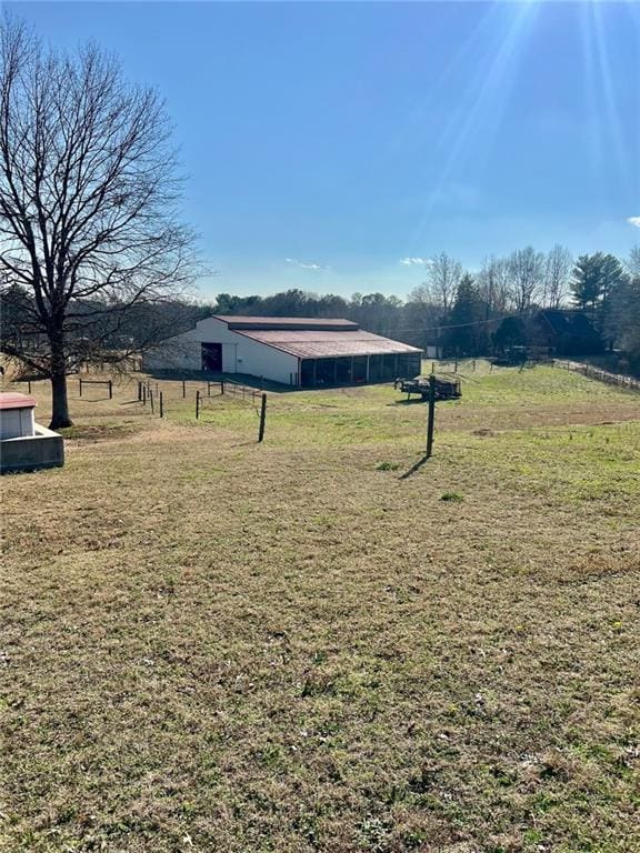 view of yard with an outdoor structure and a rural view