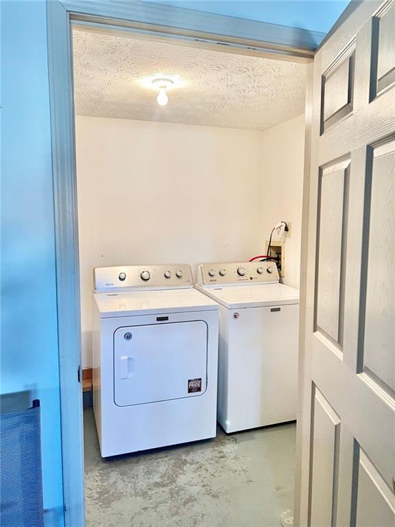 washroom featuring separate washer and dryer and a textured ceiling