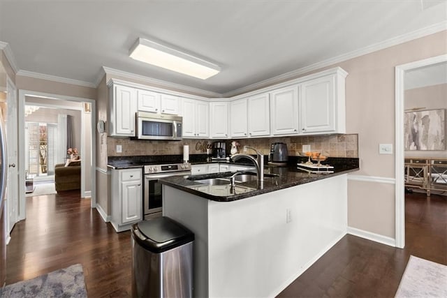 kitchen with dark wood-type flooring, sink, white cabinetry, kitchen peninsula, and stainless steel appliances