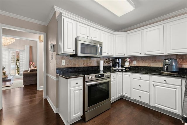 kitchen featuring dark wood-type flooring, ornamental molding, white cabinets, and appliances with stainless steel finishes