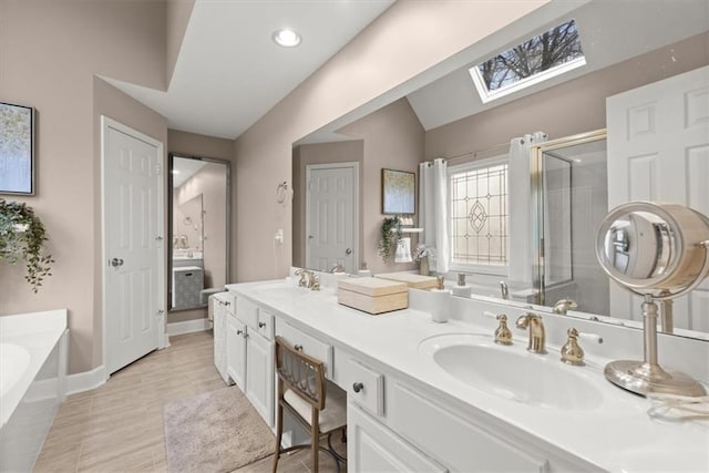 bathroom featuring plus walk in shower, lofted ceiling with skylight, and vanity