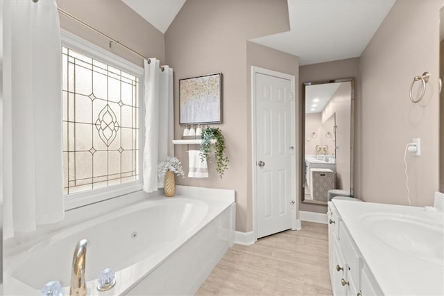 bathroom with a tub to relax in and vanity