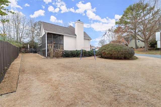 view of yard featuring a playground and a sunroom