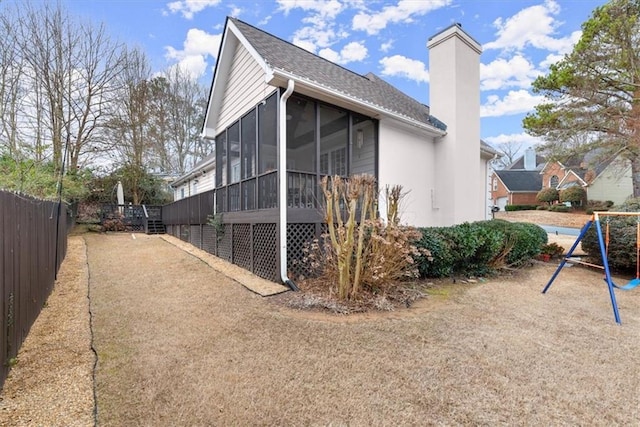 view of property exterior featuring a playground and a sunroom