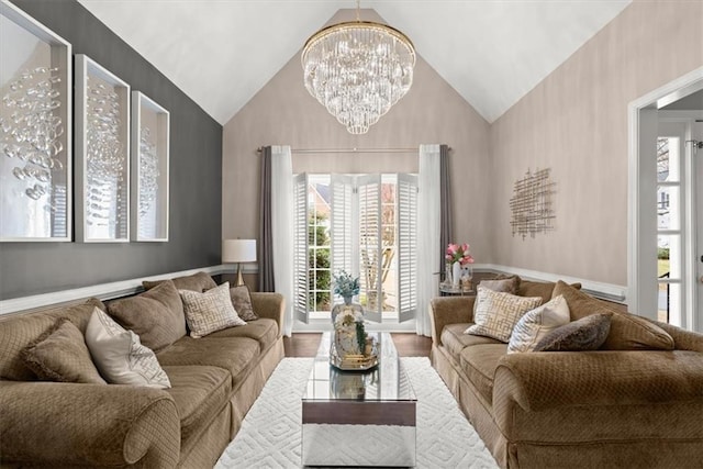 living room with a notable chandelier, hardwood / wood-style flooring, and high vaulted ceiling