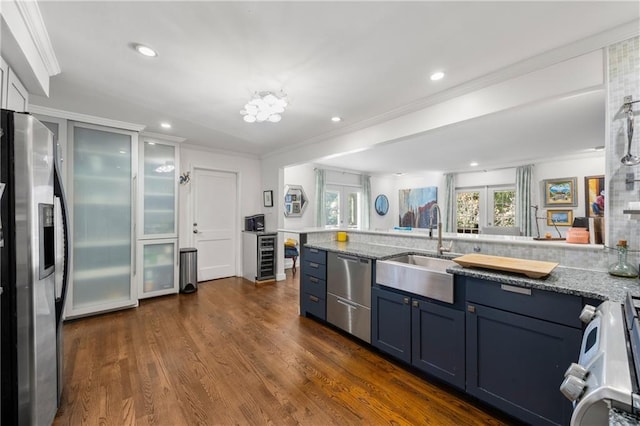 kitchen with crown molding, sink, dark hardwood / wood-style floors, appliances with stainless steel finishes, and light stone counters