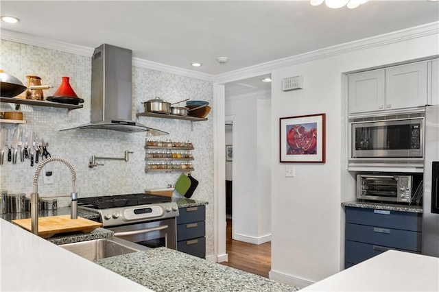 kitchen with backsplash, stainless steel appliances, ornamental molding, and wall chimney range hood