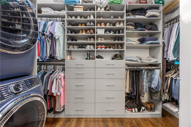 walk in closet featuring hardwood / wood-style floors and stacked washer and clothes dryer