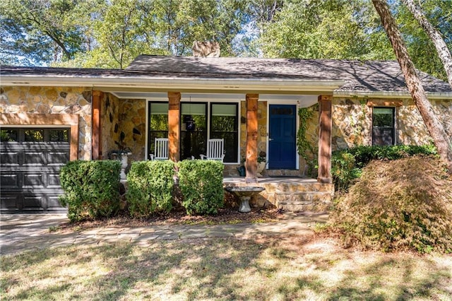 ranch-style home featuring covered porch and a garage