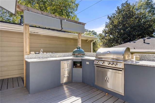 wooden terrace featuring grilling area, sink, and exterior kitchen