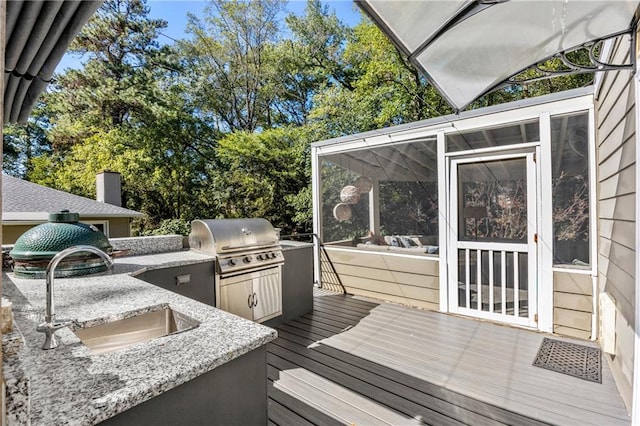 wooden deck featuring exterior kitchen, sink, and grilling area