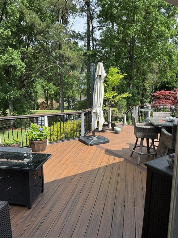 12162 Mountain Laurel Dr, Roswell, GA 30075 - wooden deck featuring outdoor dining area and view of scattered trees