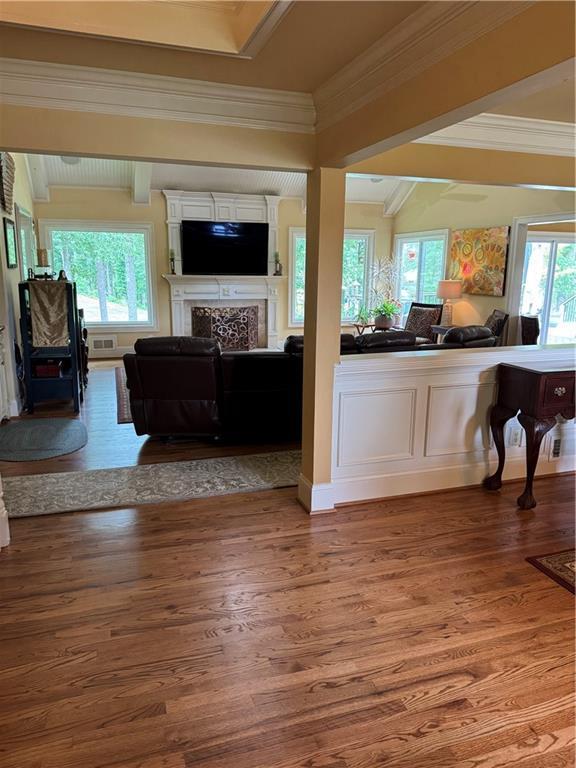 12162 Mountain Laurel Dr, Roswell, GA 30075 - living room with healthy amount of natural light, wood finished floors, a fireplace, crown molding, and beam ceiling